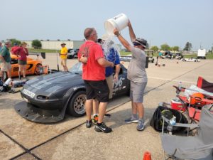 Celebrating winning a race by pouring bucket of water next to Eric Anderson's winning race car